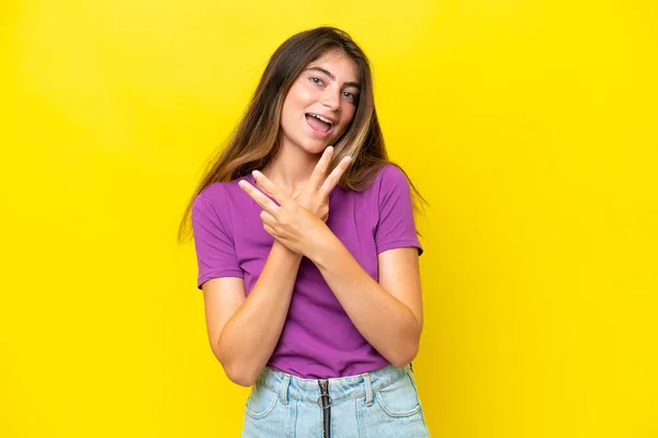 Νεαρή Καυκάσια Γυναίκα Απομονωμένη Κίτρινο Φόντο Χαμογελώντας Και Δείχνοντας Σύμβολο — Φωτογραφία Αρχείου