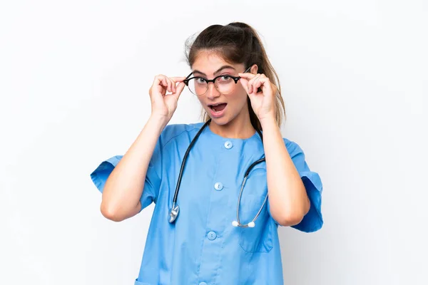 Enfermera Joven Doctora Aislada Sobre Fondo Blanco Con Gafas Sorprendida —  Fotos de Stock
