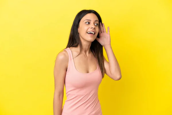 Young Caucasian Woman Isolated Yellow Background Listening Something Putting Hand — Stock Photo, Image