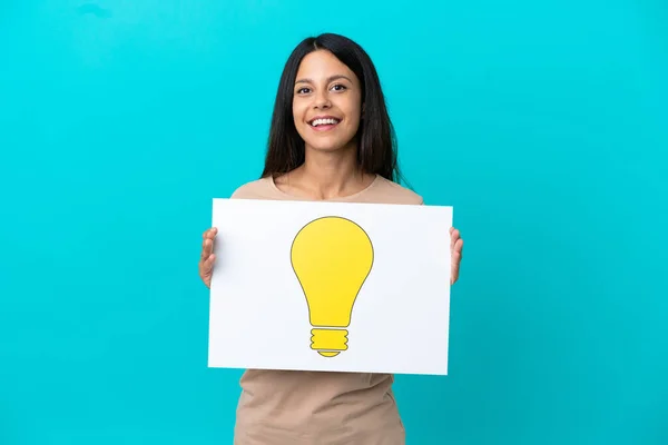 Young Woman Isolated Background Holding Placard Bulb Icon Happy Expression — Stock Photo, Image