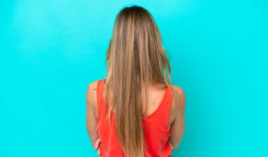 Genç beyaz kadın arka planda mavi arka planda izole edilmiş.