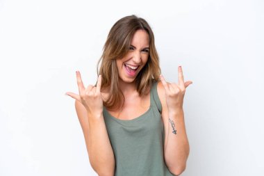 Beyaz arka planda izole edilmiş genç beyaz kadın boynuz hareketi yapıyor.