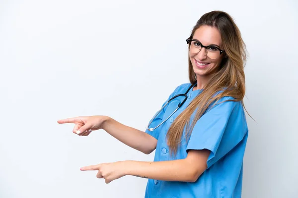 若い外科医の医師の女性は 側に指を指して 製品を提示青い背景に隔離 — ストック写真