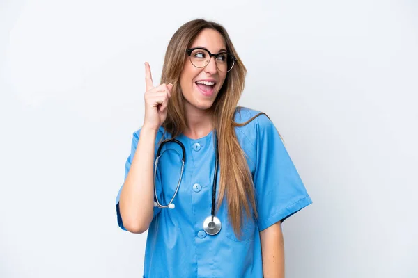 指を持ち上げながら解決策を実現しようと青色の背景に隔離された若い外科医の医師の女性 — ストック写真
