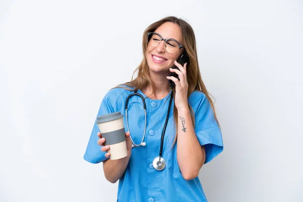 若い外科医の医師女性隔離上の青背景色保持コーヒーへ取り去ると携帯電話 — ストック写真