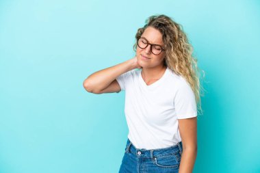 Kıvırcık saçlı kız mavi arka planda, boynu ağrıyan.