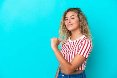 Kıvırcık saçlı kız mavi arka planda soyutlanmış gururlu ve kendini beğenmiş