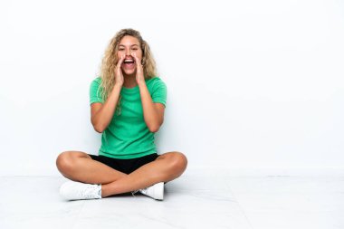 Girl with curly hair sitting on the floor shouting and announcing something
