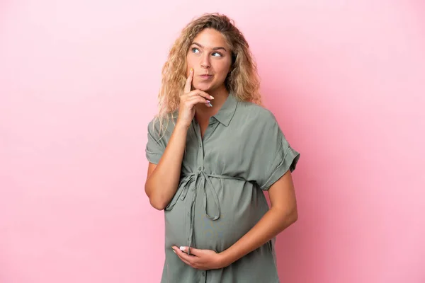 Chica Con Pelo Rizado Aislado Sobre Fondo Rosa Embarazada Pensando —  Fotos de Stock