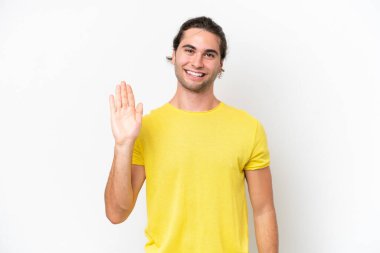 Caucasian handsome man isolated on white background saluting with hand with happy expression