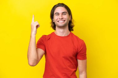 Caucasian handsome man isolated on yellow background pointing up a great idea