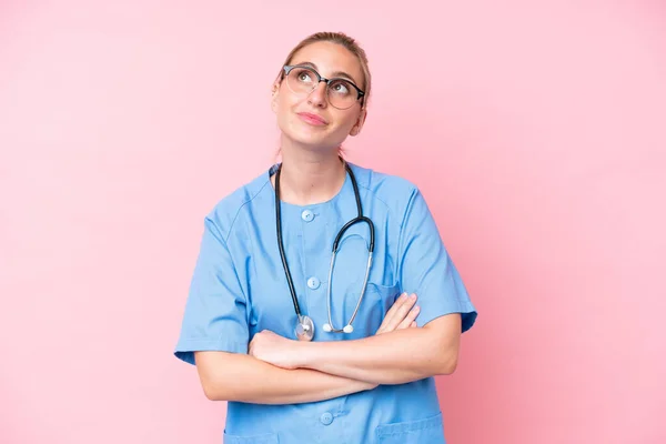 Fiatal Sebész Nővér Elszigetelt Rózsaszín Háttér Felnéz Miközben Mosolyog — Stock Fotó