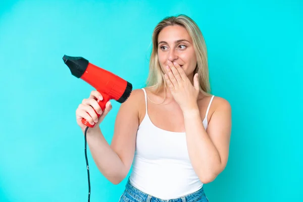 Young Caucasian Woman Holding Hairdryer Isolated Blue Background Surprise Shocked — Stock Photo, Image