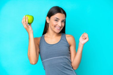 Kafkasyalı genç bir kadın mavi arka planda yalnız ve mutlu.