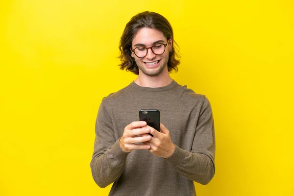 Caucasian Handsome Man Isolated Yellow Background Sending Message Mobile — Zdjęcie stockowe