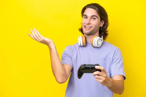 Молодой Красивый Белый Мужчина Играет Контроллером Видеоигры Над Изолированным Желтом — стоковое фото