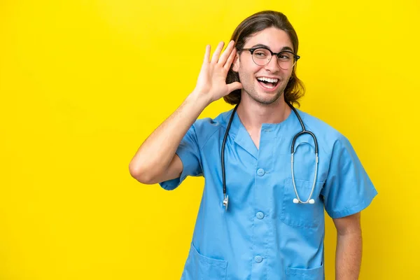 Young Surgeon Caucasian Man Isolated Yellow Background Listening Something Putting — Stockfoto