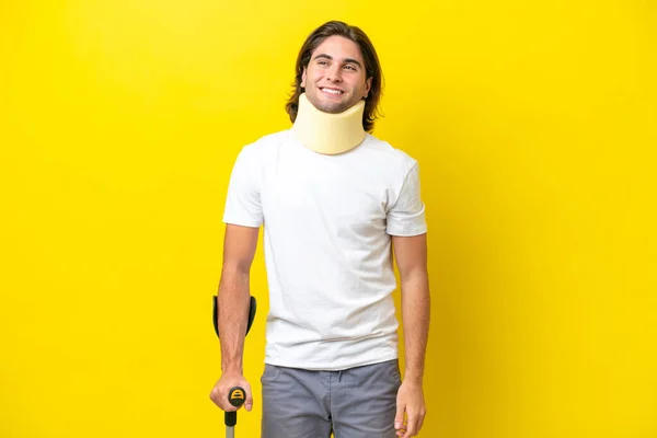 Young Handsome Man Wearing Neck Brace Crutches Isolated Yellow Background — Stockfoto