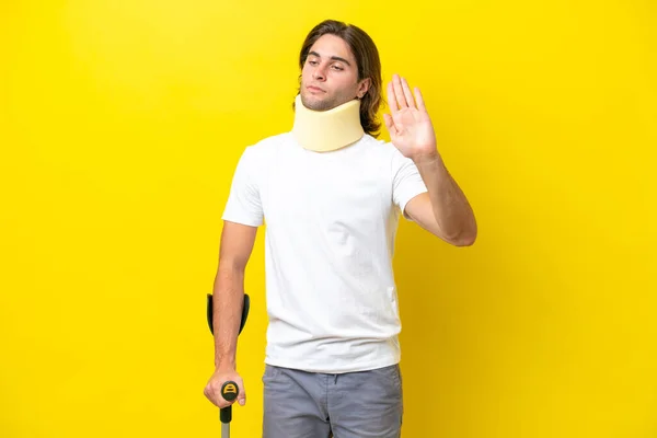 Young Handsome Man Wearing Neck Brace Crutches Isolated Yellow Background — Stockfoto