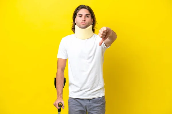 Young Handsome Man Wearing Neck Brace Crutches Isolated Yellow Background — Stockfoto