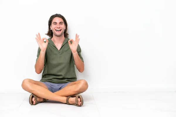 Young Handsome Man Sitting Floor Isolated White Background Showing Sign — Stockfoto