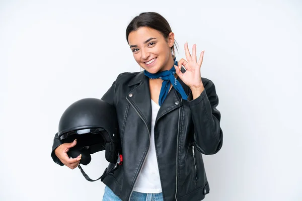 若いですCaucasian女性とともにオートバイヘルメット隔離上の青背景ショーOkサインとともに指 — ストック写真