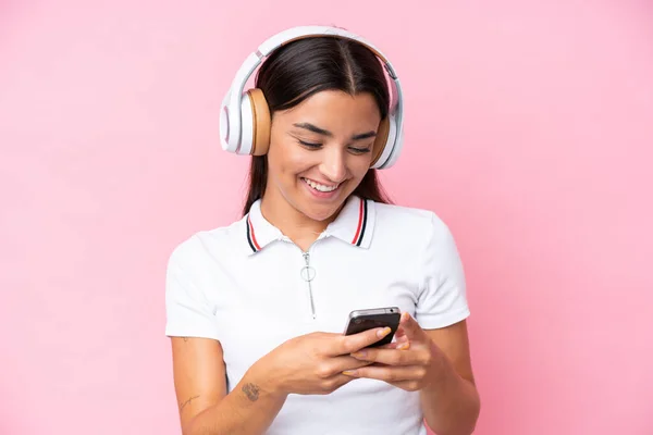 Jovem Caucasiana Isolada Fundo Rosa Ouvindo Música Olhando Para Celular — Fotografia de Stock