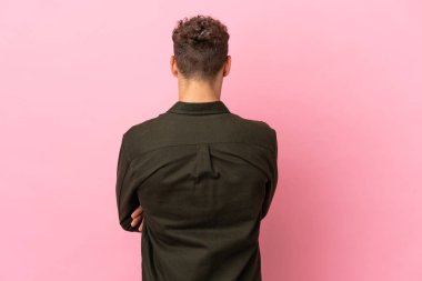 Pembe arka planda izole edilmiş yakışıklı, beyaz bir adam.