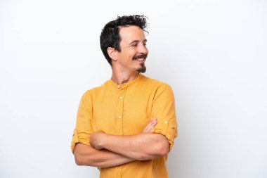 Bıyıklı genç adam beyaz arka planda izole edilmiş, yana bakıyor ve gülümsüyor.