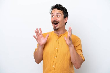 Bıyıklı genç bir adam, beyaz arka planda, şaşırmış bir yüz ifadesi var.