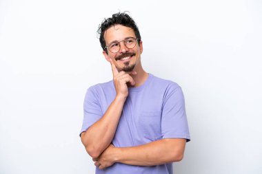 Young man with moustache isolated on white background thinking an idea while looking up