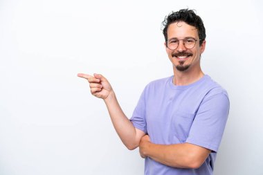 Young man with moustache isolated on white background pointing finger to the side