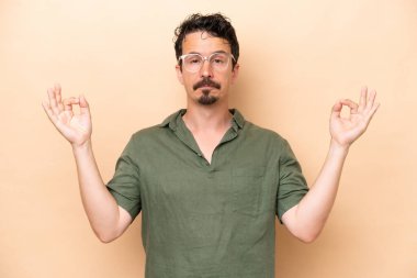 Zen pozunda bej arka planda izole edilmiş beyaz bir genç.