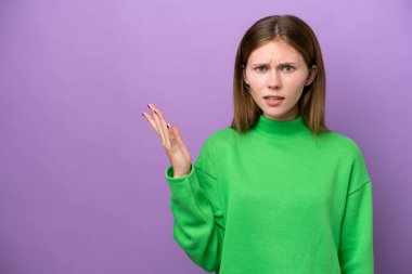 Mor arka planda izole edilmiş genç bir İngiliz kadın şüpheli hareketler yapıyor.