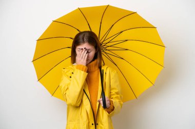 Young English woman with rainproof coat and umbrella isolated on white background with tired and sick expression