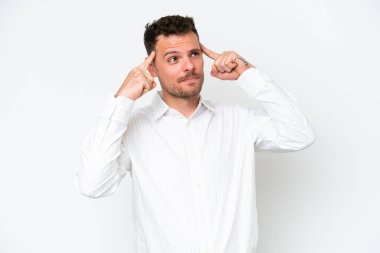 Beyaz arka planda soyutlanmış beyaz, yakışıklı genç bir adam. Şüpheleri ve düşünceleri var.