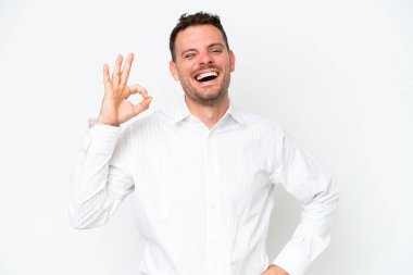 Beyaz arka planda izole edilmiş beyaz tenli yakışıklı bir adam parmaklarıyla işaret veriyor.