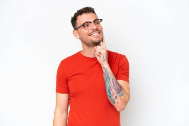 Beyaz arka planda izole edilmiş beyaz tenli yakışıklı bir adam yukarı bakarken bir fikir düşünüyor.