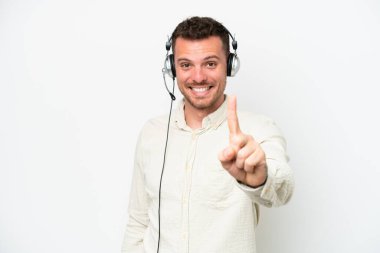 Tele pazarlamacı, beyaz arka planda izole edilmiş bir kulaklıkla çalışan beyaz bir adam parmak kaldırıyor.