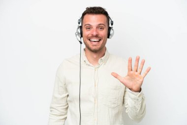 Beyaz arka planda izole edilmiş kulaklıkla çalışan beyaz pazarlamacı beyaz adam parmaklarıyla beşi sayıyor.