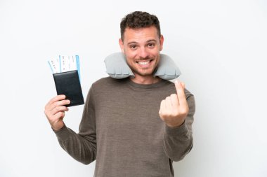 Young caucasian man holding a passport isolated on white background making money gesture