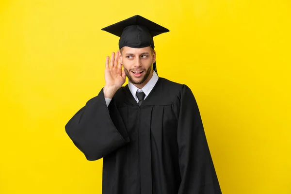Νεαρός Απόφοιτος Πανεπιστημίου Καυκάσιος Άνδρας Απομονωμένος Κίτρινο Φόντο Ακούγοντας Κάτι — Φωτογραφία Αρχείου