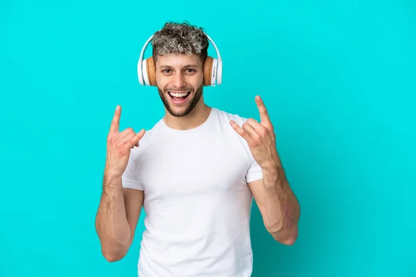Νεαρός Όμορφος Καυκάσιος Άνδρας Απομονωμένος Μπλε Φόντο Ακούγοντας Μουσική Κάνοντας — Φωτογραφία Αρχείου