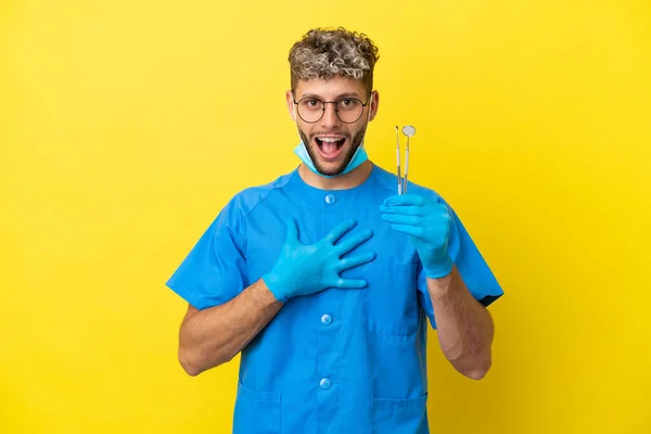 Dentist Caucasian Man Holding Tools Isolated Yellow Background Surprised Shocked — Zdjęcie stockowe