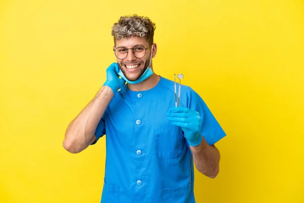 Dentista Caucasiano Homem Segurando Ferramentas Isoladas Fundo Amarelo Rindo — Fotografia de Stock
