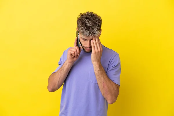 Young Caucasian Man Using Mobile Phone Isolated Yellow Background Tired — Zdjęcie stockowe
