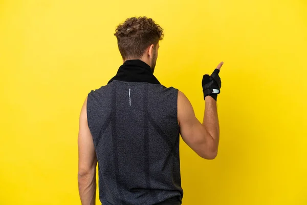 Sport Caucasian Man Isolated Yellow Background Pointing Back Index Finger — 图库照片