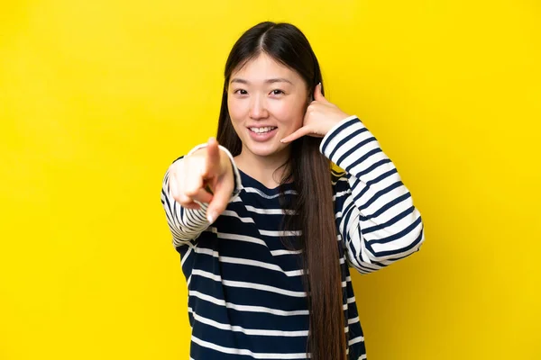 Young Chinese Woman Isolated Yellow Background Making Phone Gesture Pointing — Foto Stock