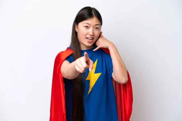 Super Hero Chinese woman isolated on white background making phone gesture and pointing front