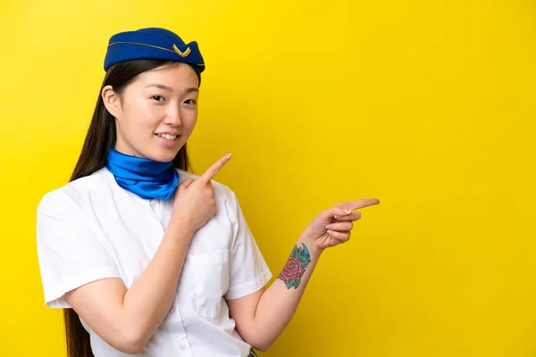 Airplane Chinese Woman Stewardess Isolated Yellow Background Pointing Finger Side — Foto Stock